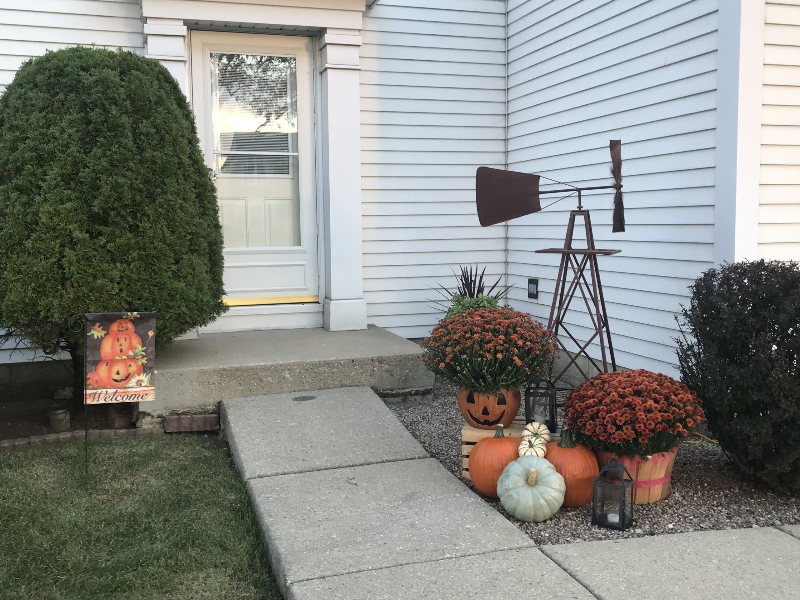 front of our house decorated for fall with mums and pumpkins